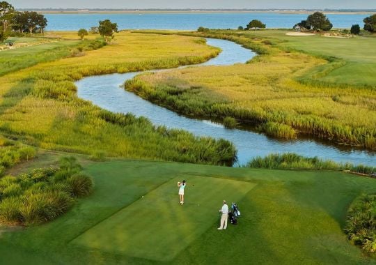 A woman teeing off on the golf course at sea island