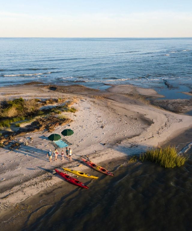 Aerial shot of family walking on beach after kayaking