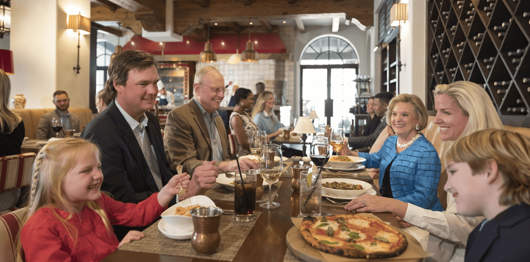 Family sitting at table while eating and talking