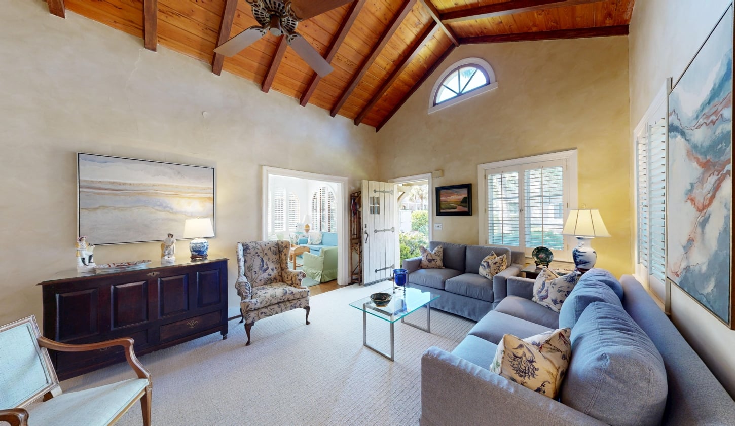 A living room with large windows and a door leading outside