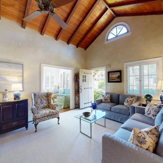 A living room with large windows and a door leading outside
