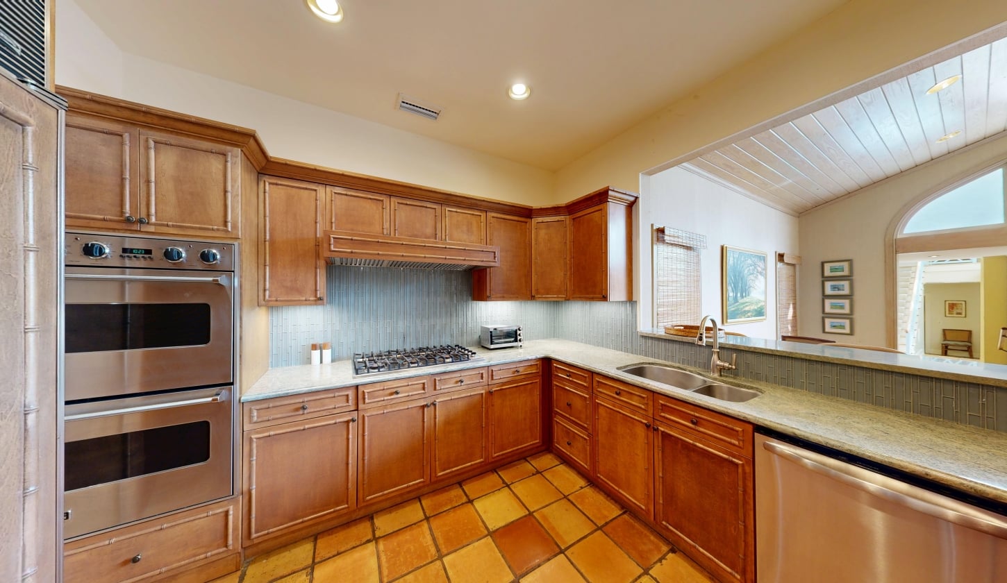 A kitchen with a gas range stove and wood cabinetry