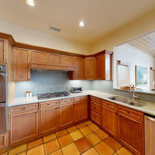 A kitchen with a gas range stove and wood cabinetry