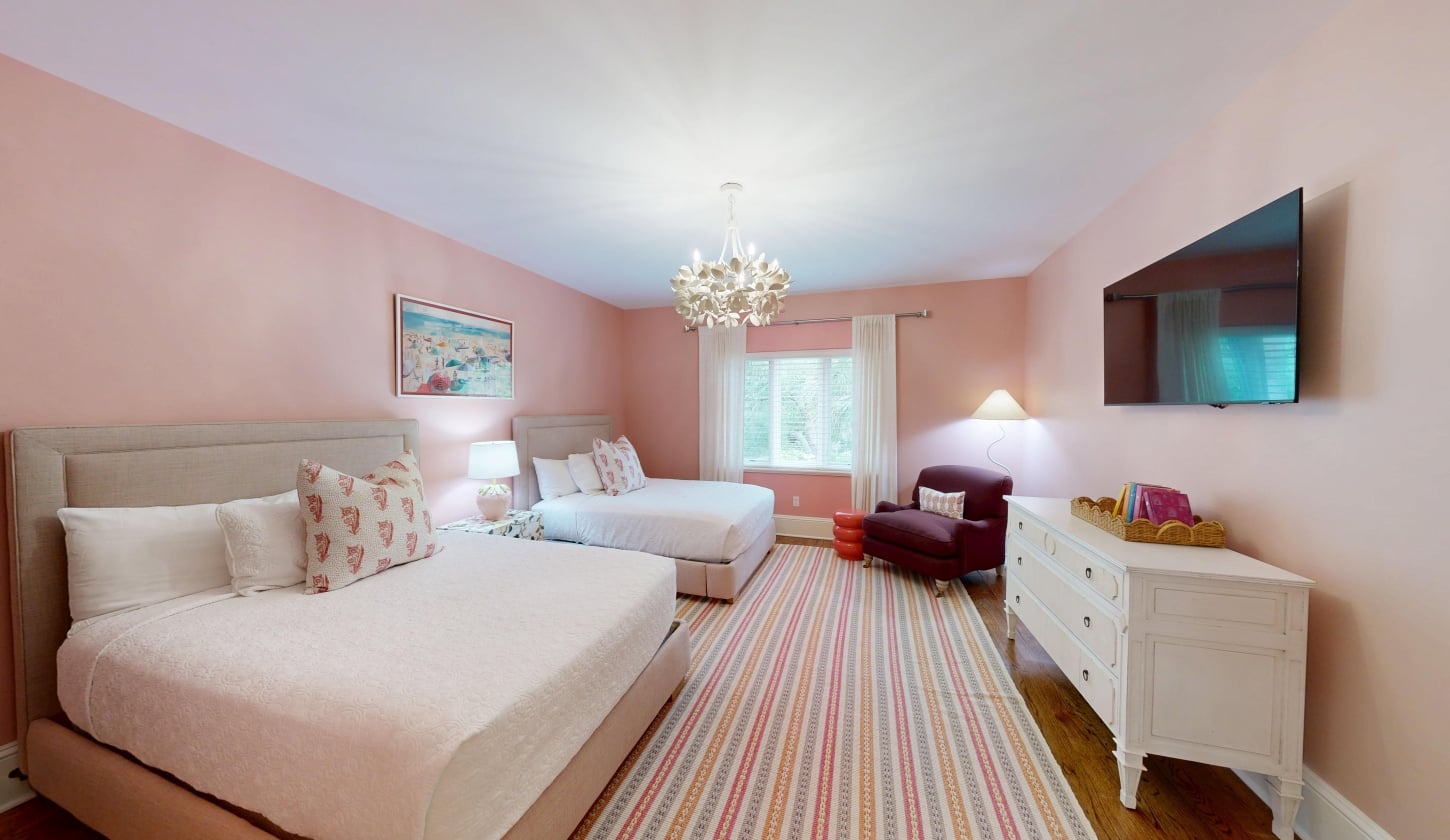 A soft pink bedroom with two queen beds
