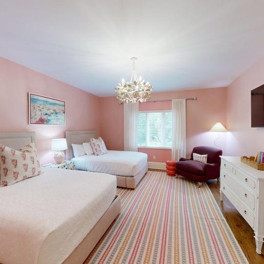 A soft pink bedroom with two queen beds