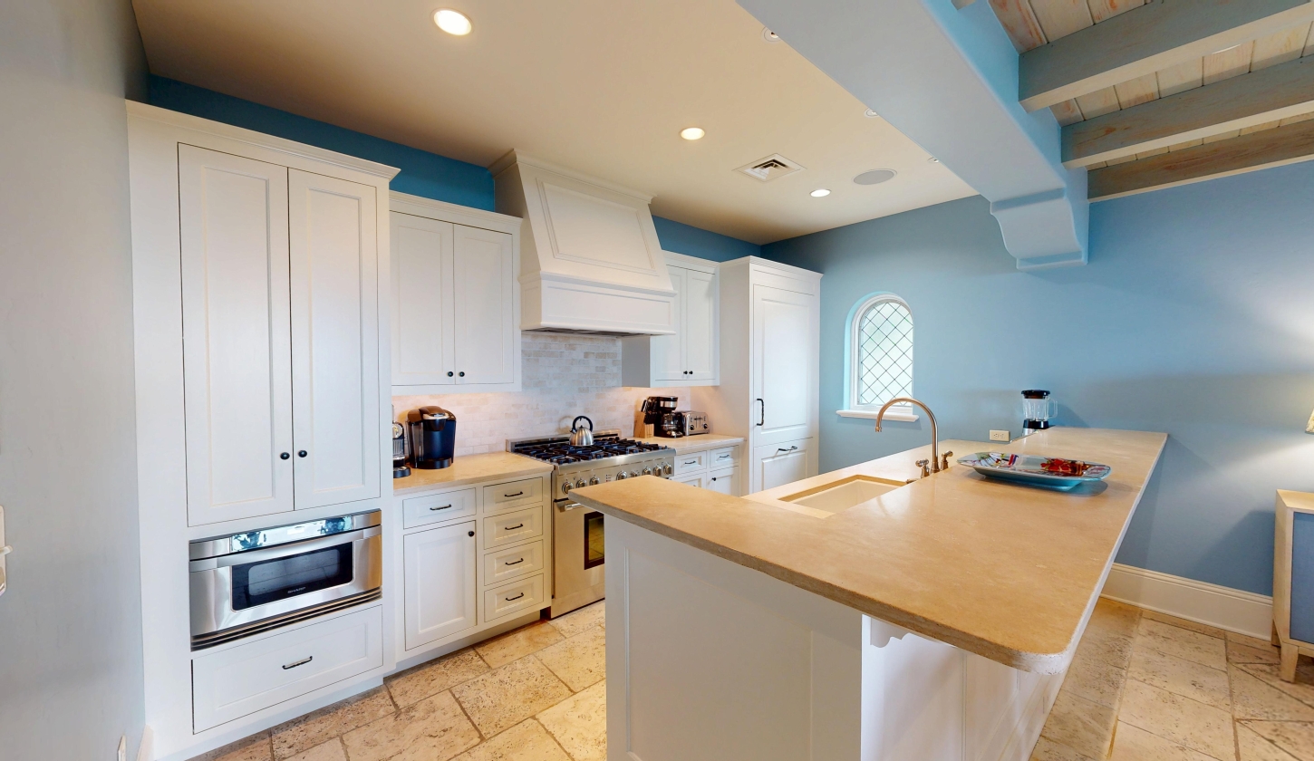 A kitchen with white cabinets and a gas range stove