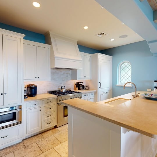 A kitchen with white cabinets and a gas range stove