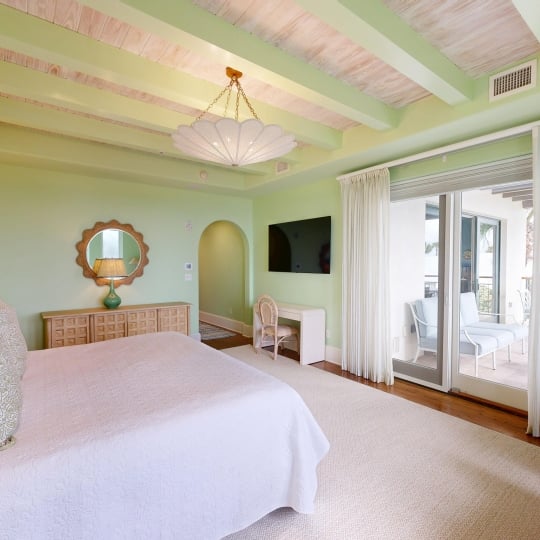 A spacious bedroom with a door leading out to a patio