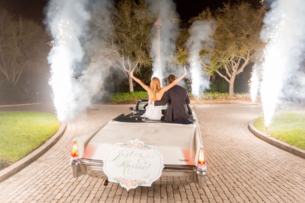 bride and groom driving away