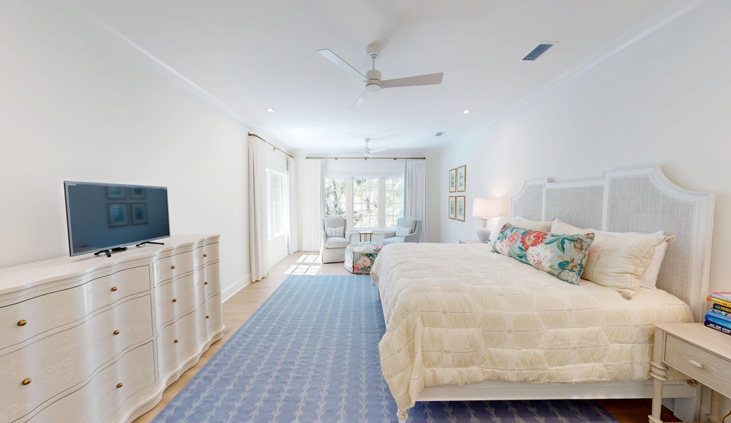 A bright bedroom with a blue rug