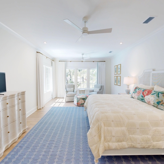 A bright bedroom with a blue rug