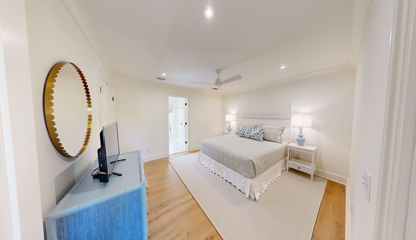 A spacious bedroom with a king bed and white rug