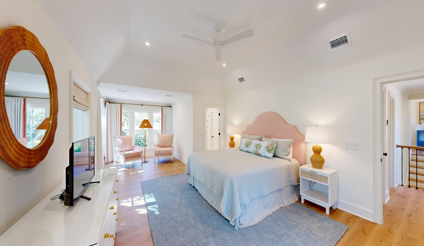 A spacious bedroom with large windows and a king bed