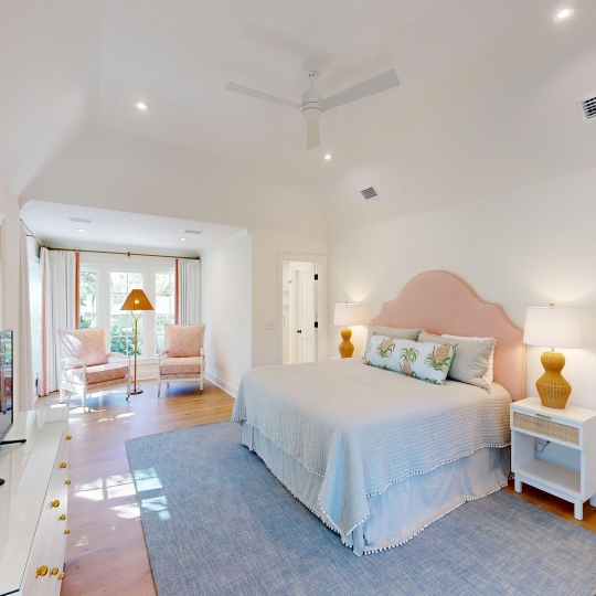 A spacious bedroom with large windows and a king bed