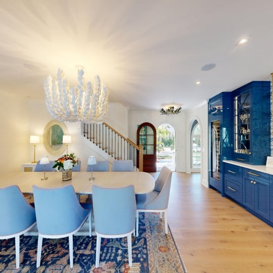 A dining table beside blue cabinetry