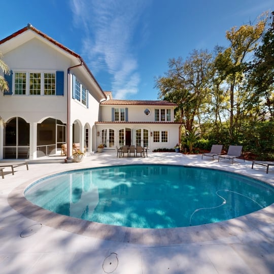 A private circular pool in the backyard of a large cottage