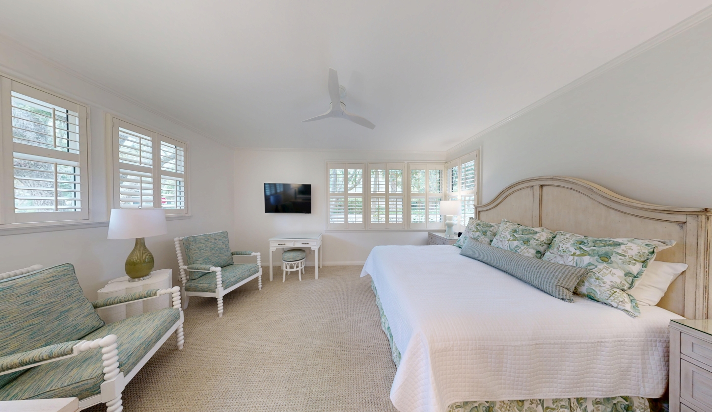 A large bed beside a row of windows