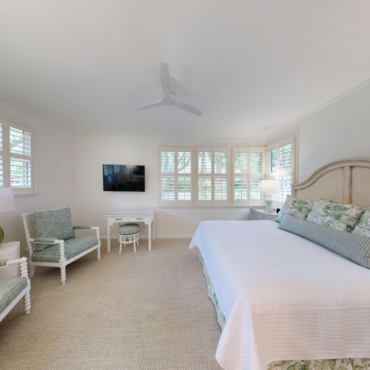 A large bed beside a row of windows