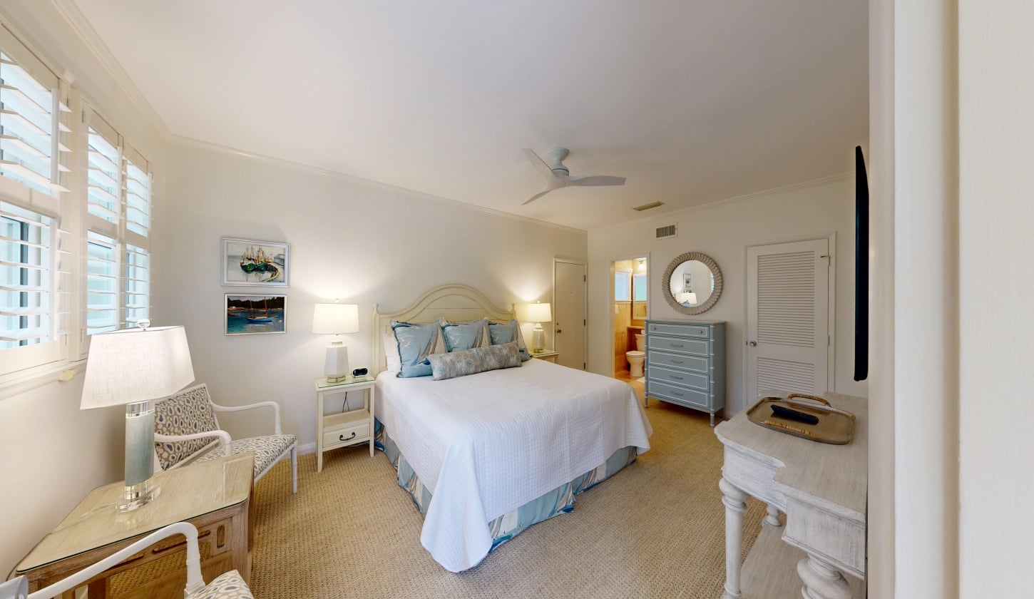 A large bed with a white duvet and gray pillows