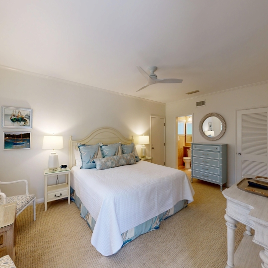 A large bed with a white duvet and gray pillows