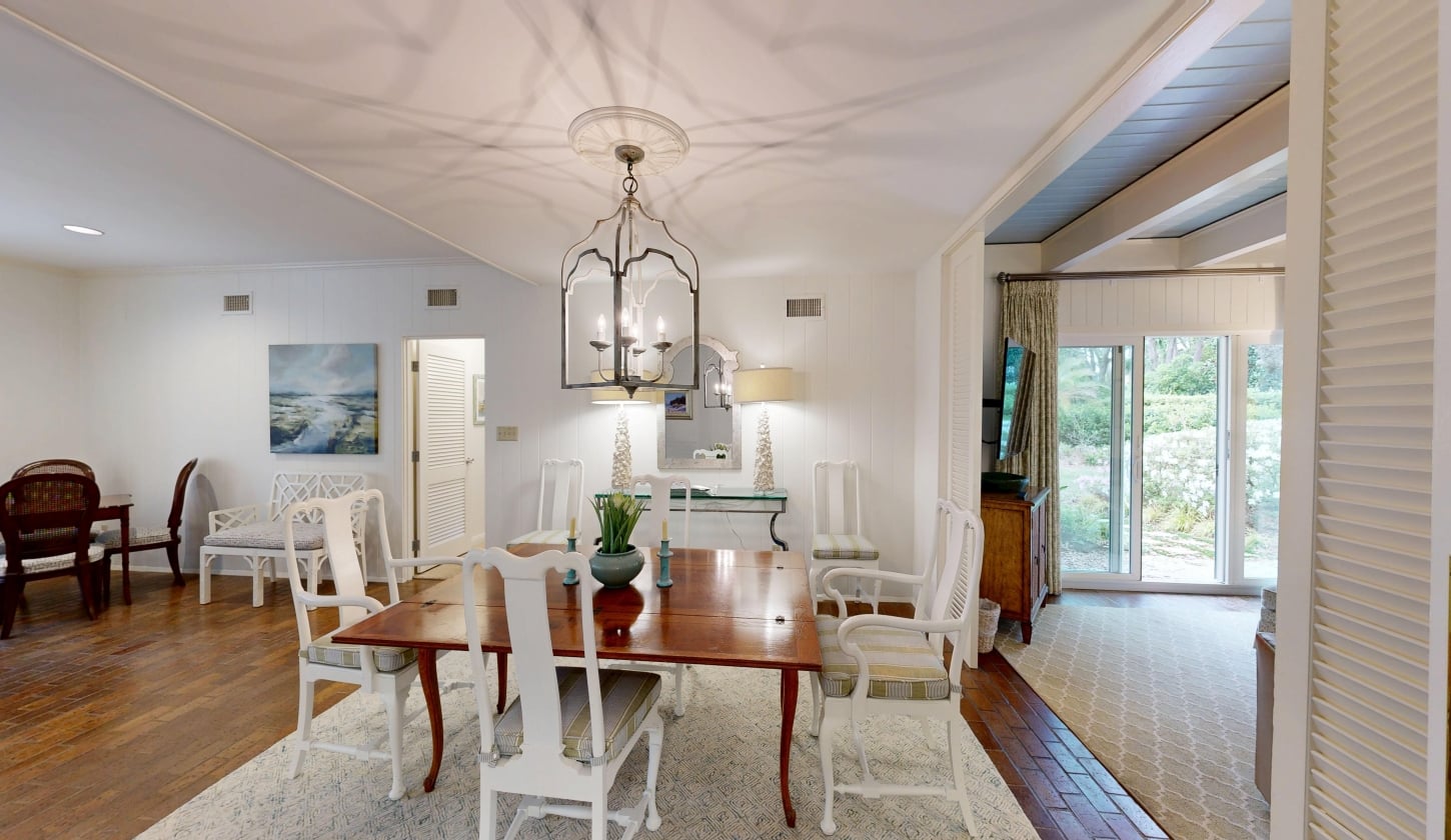 A dining table site underneath a chandelier