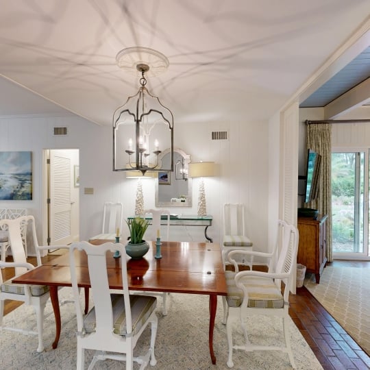 A dining table site underneath a chandelier