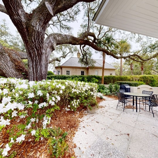 An outdoor patio with white flowers around the outside