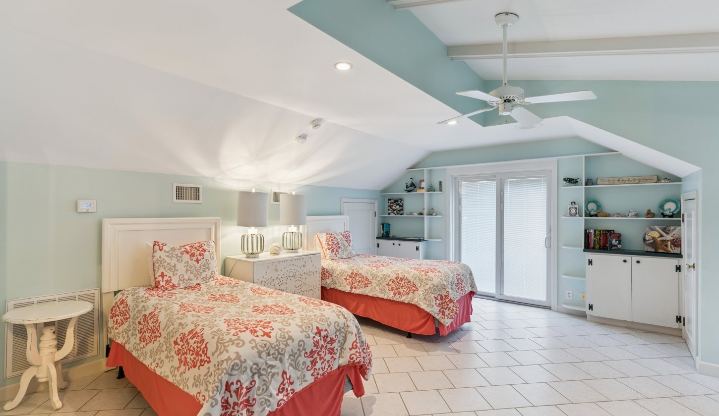 A spacious room with two beds separated by a dresser