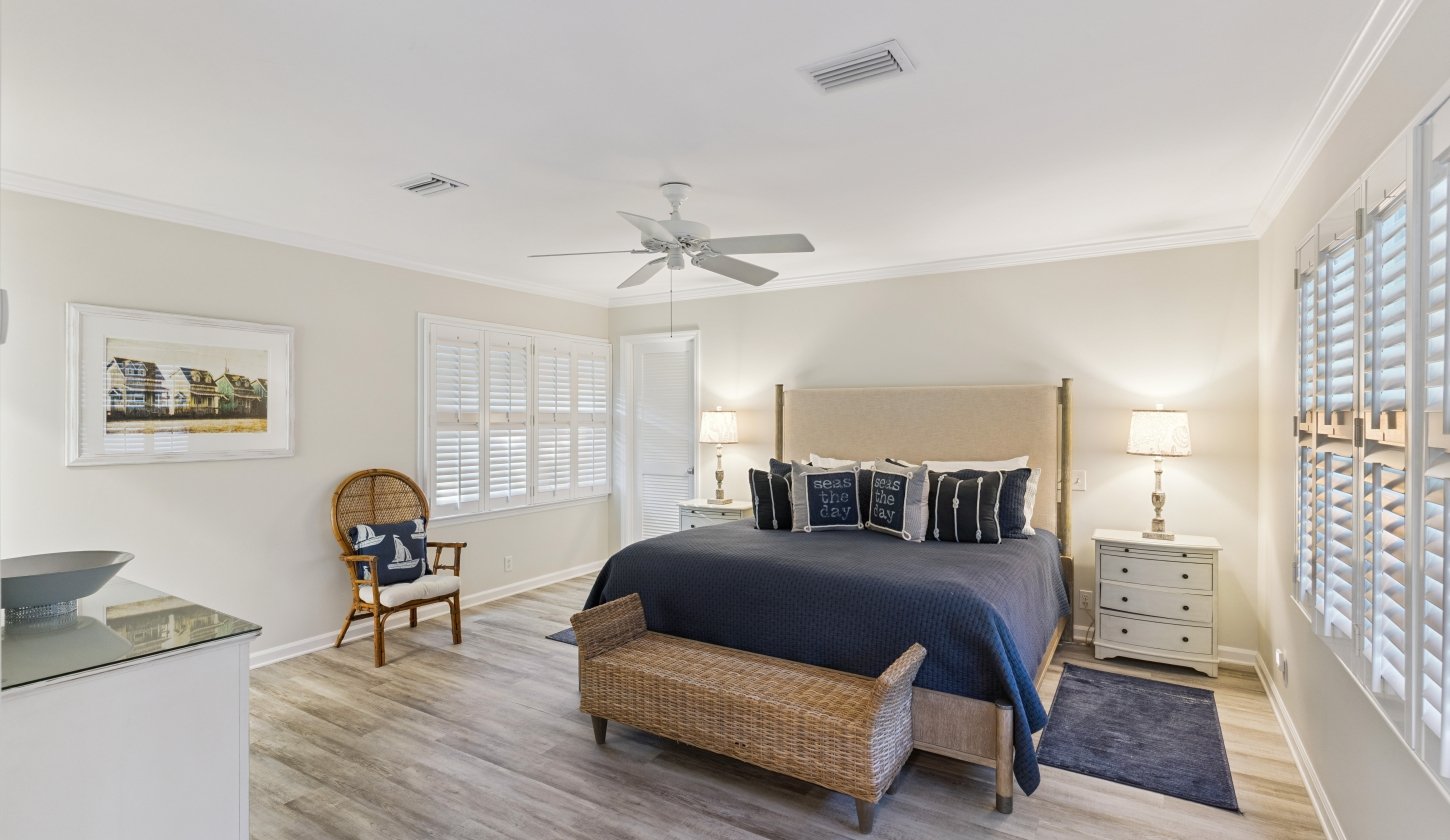 A large bed with dark blue accents in a white room
