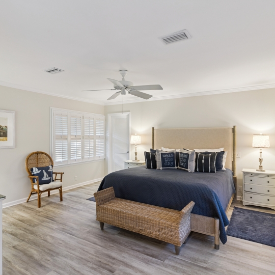 A large bed with dark blue accents in a white room