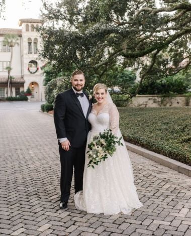bride and groom posing near a park