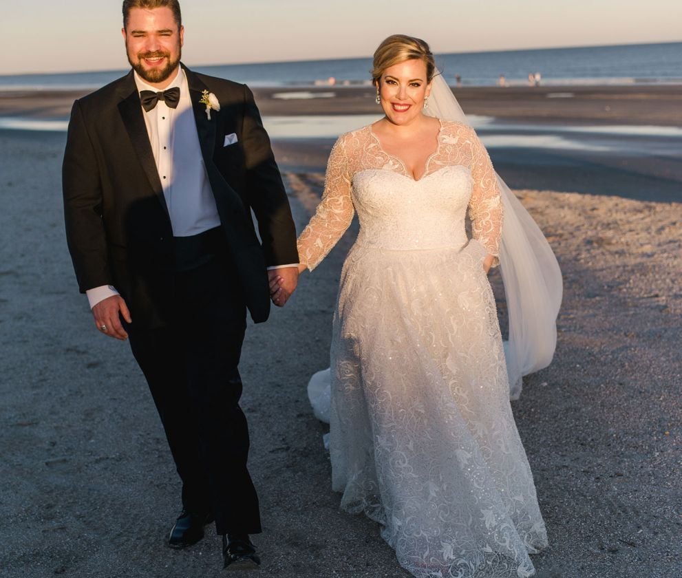 bride and groom walking on the beach