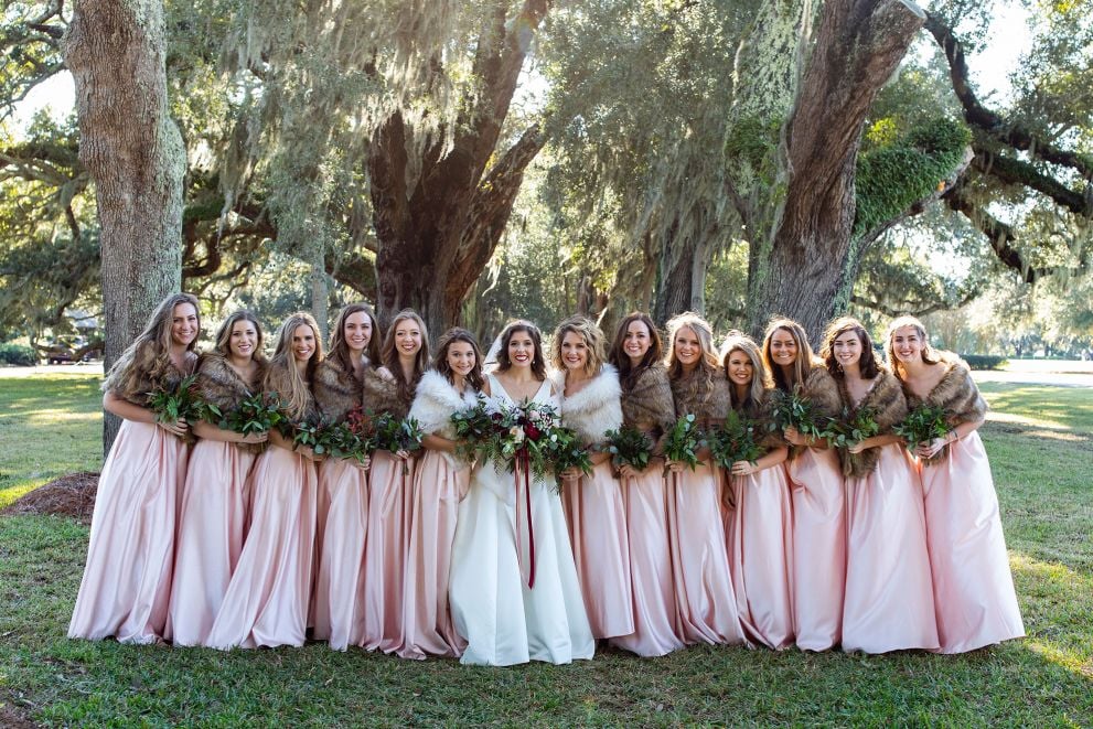 bridal party posing in front of trees