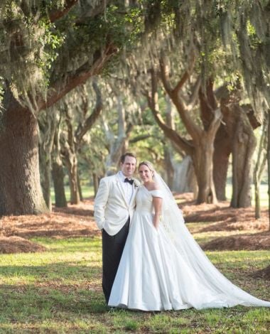 bride and groom posing in a park