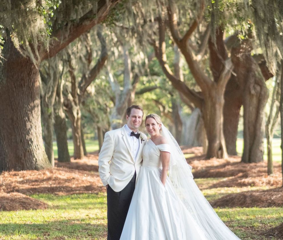 bride and groom posing in a park
