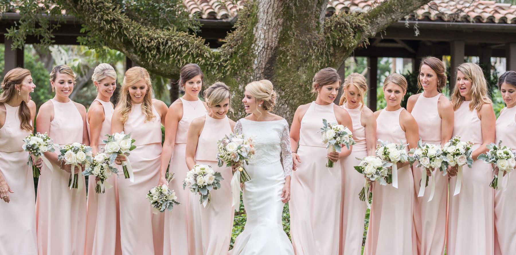 bridal party posing in front of a tree