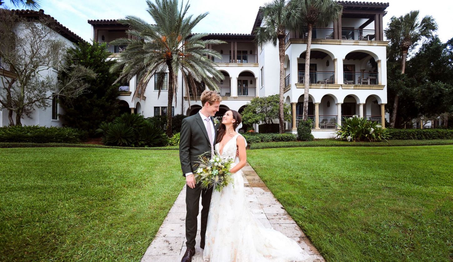 a bride and groom pose for a photo outdoors at Sea Island