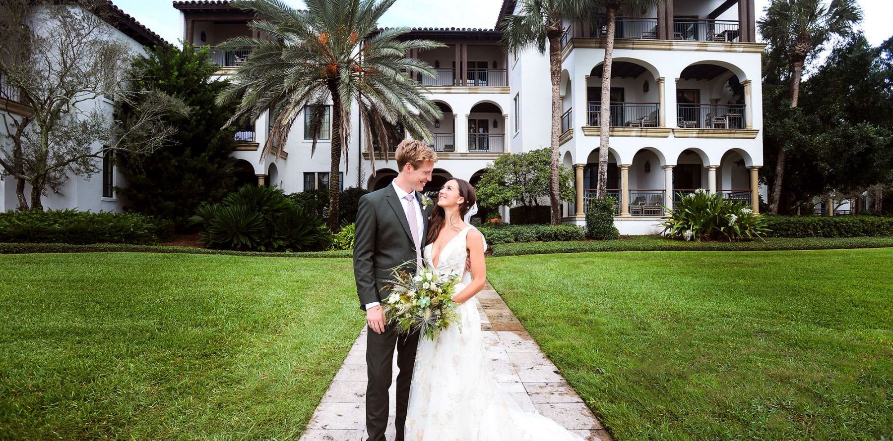 a bride and groom pose for a photo outdoors at Sea Island