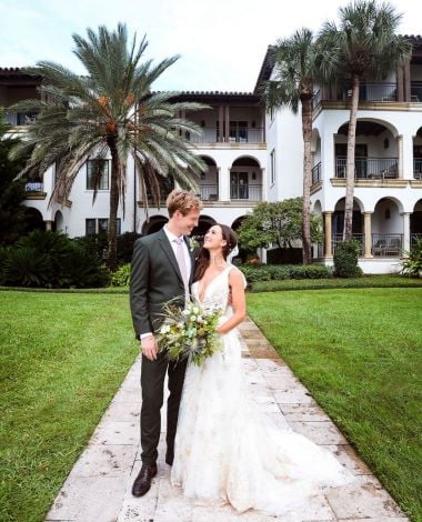 a bride and groom pose for a photo outdoors at Sea Island