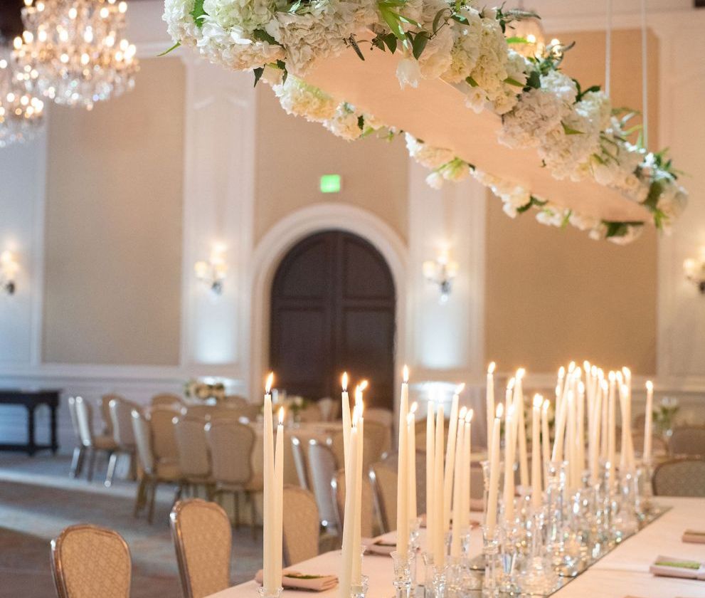 dining table set up with hanging center piece and tall candles
