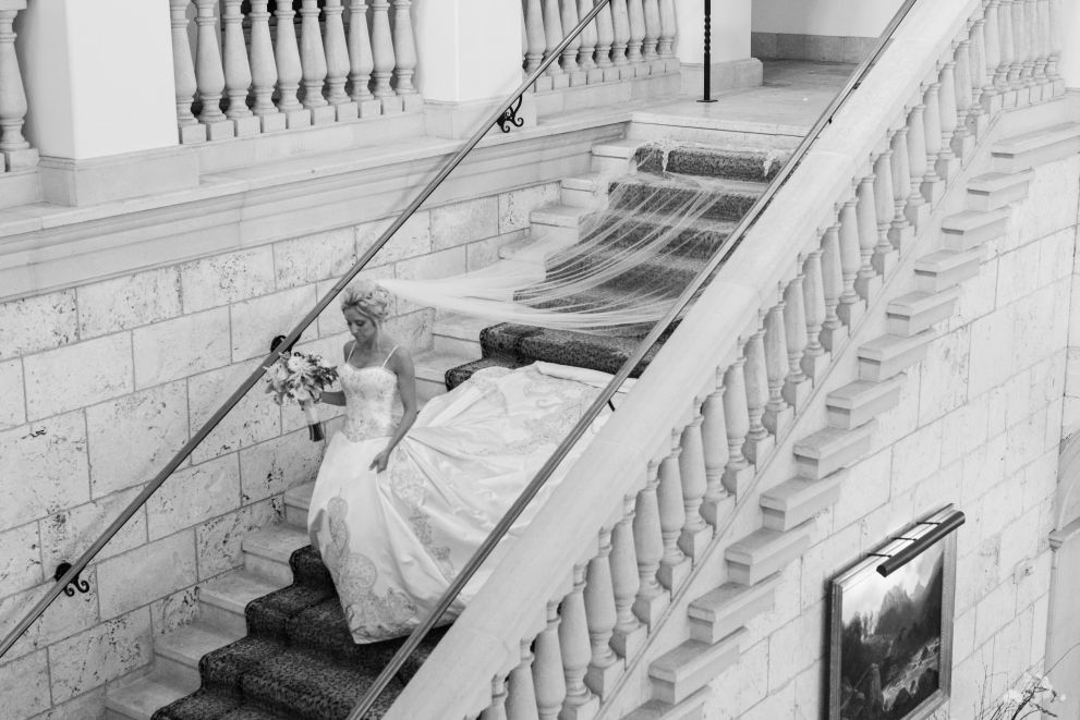 black and white photo of bride walking down the stairs