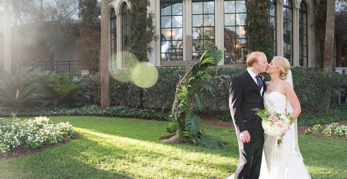a bride and groom kiss on the lawn at Sea Island