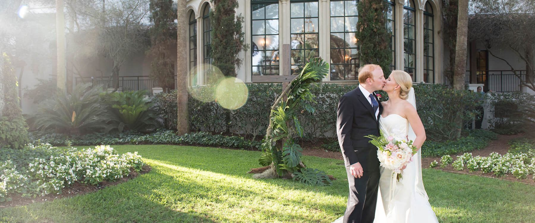 a bride and groom kiss on the lawn at Sea Island