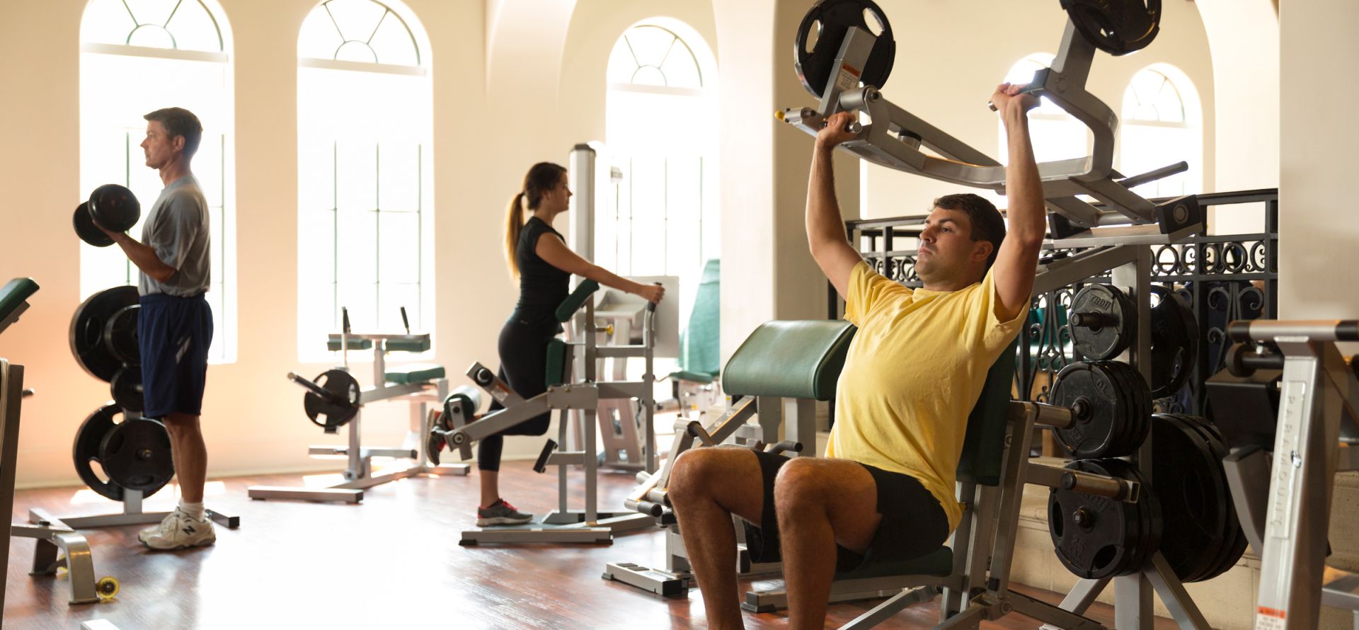 a group of people lifting weights and working out during a sea island fitness class