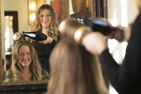 Woman receiving salon blowout hair treatment