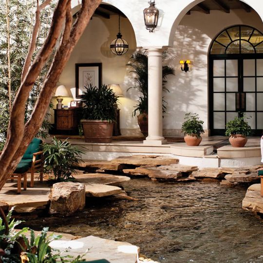 A woman seating on a chair at the spa garden atrium in Sea Island Resort