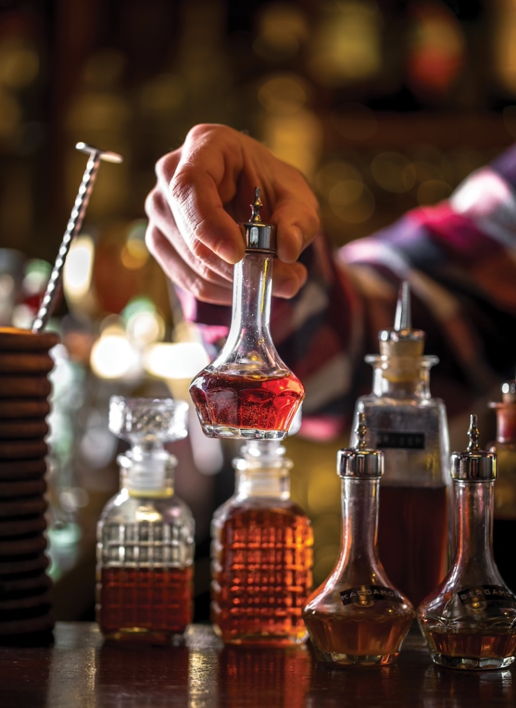 Angostura bitters standing on the bar. Preparing a cocktail. Night club scenery.