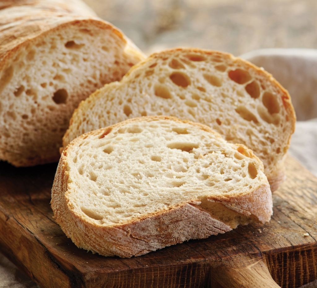 freshly baked ciabatta bread on wooden cutting board