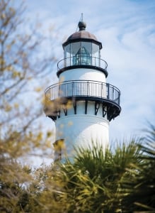 A vintage, operational lighthouse guards the deepwater inlet for nautical safety near the shipping lane