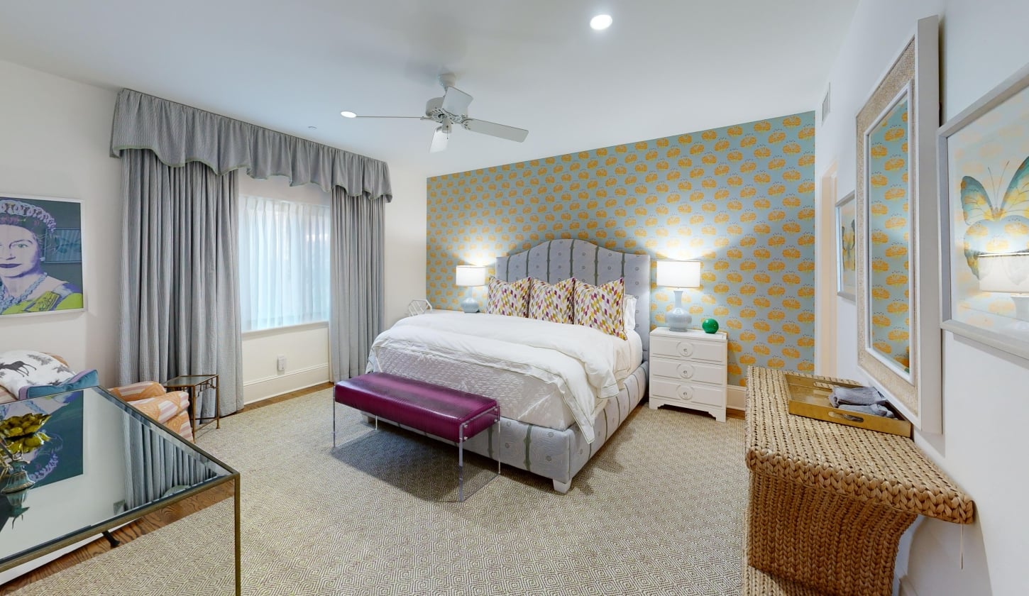 A spacious bedroom featuring a king bed and a large window